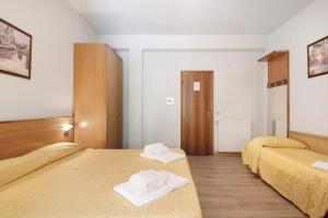 two beds in a room with towels on them at Appartamento Monolocale Moneglia 35 in Moneglia