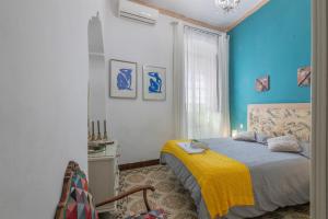 a bedroom with blue walls and a bed with a yellow blanket at Una casa azul in Manzanilla