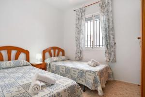 a bedroom with two beds and a window at Sagasta 1 - Andalmar in Conil de la Frontera +12 photos