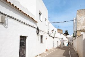 an alley with white buildings and a door at Sagasta 1 - Andalmar in Conil de la Frontera