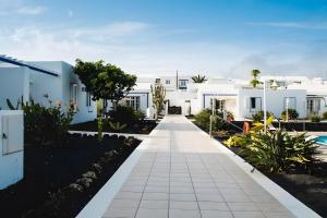 a walkway in front of a white house at Bungalow 2 - Caleta Campos in Arrieta