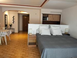 a bedroom with a bed with white pillows and a table at Unique apartahotel 2-1 in Torrevieja