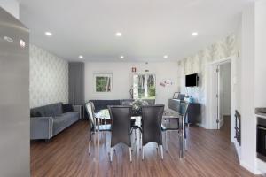 a dining room and living room with a table and chairs at Moradia Pinheiro Manso in Apúlia