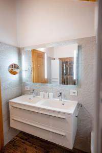 a bathroom with a white sink and a mirror at Appartamento Bucaneve in Predazzo +19 photos