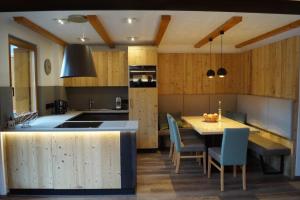 a kitchen with a table and some blue chairs at Appartamento Bucaneve in Predazzo