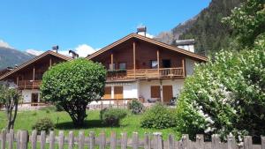a house with a fence in front of it at Appartamento Bucaneve in Predazzo
