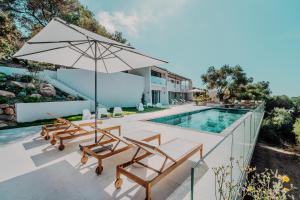 an external view of a villa with a swimming pool at La Thébaïde in Cargèse
