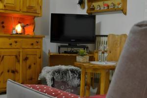 a living room with a tv and a table with a chair at Maison Wanda La Salle in La Salle