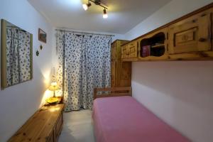 a small bedroom with a bed and a window at Maison Wanda La Salle in La Salle