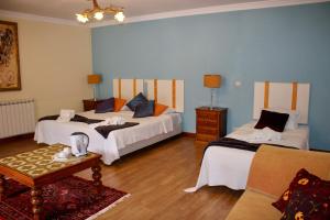 a bedroom with two beds and a table and a couch at Solar de Rabal in Bragança +168 photos