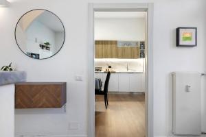 a hallway leading into a kitchen with a mirror on the wall at Dante210 in Cassina Rizzardi +35 photos