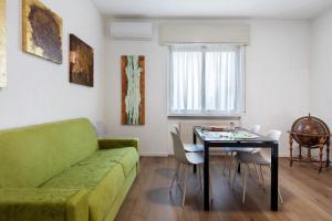 a living room with a green couch and a table at Dante210 in Cassina Rizzardi
