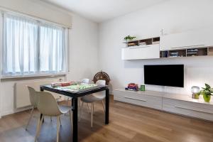 a dining room with a table and chairs and a television at Dante210 in Cassina Rizzardi