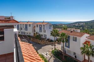 a view of a town with houses and palm trees at Atico Duplex con terraza in Manilva