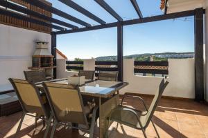 a dining room with a table and chairs on a balcony at Atico Duplex con terraza in Manilva
