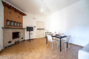 a living room with a table and chairs and a fireplace at La casa di Greta in Marcelli