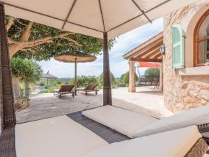 an outdoor patio with an umbrella and chairs at Ses Mires in Santanyi