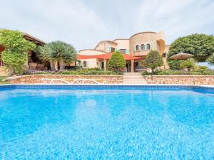 a large blue swimming pool in front of a house at Ses Mires in Santanyi