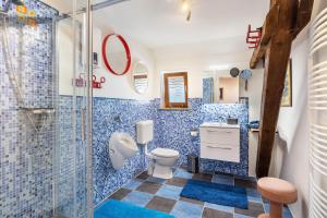 a blue tiled bathroom with a toilet and a shower at Offene Galerie-Fewo auf 2 Etagen in Bad Gandersheim +17 photos