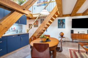 a kitchen and dining room with blue cabinets and a wooden table at Offene Galerie-Fewo auf 2 Etagen in Bad Gandersheim