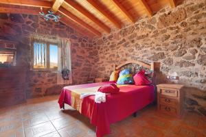 a bedroom with a bed and a stone wall at Casa los Javieles in Puerto del Rosario