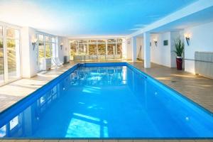 a swimming pool with blue water in a house at Waldquartier in Schönwald