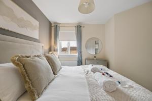 a bedroom with a bed with white sheets and a window at Lees Apartment in Coatbridge