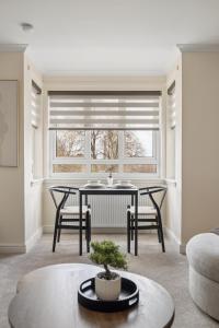 a living room with a table and chairs and a window at Lees Apartment in Coatbridge +33 photos