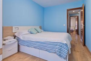 a blue room with a bed and a blue wall at Vivienda Turística Osiris in San Andrés del Rabanedo