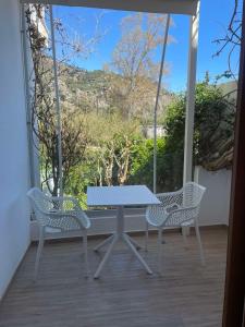 a white table and chairs on a porch with a view at Lissos Rooms Sougia in Sougia