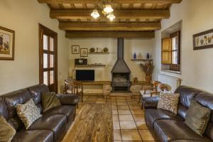 a living room with leather couches and a fireplace at La Torre de Dalt in Santa María de Camós