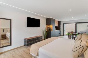 a bedroom with a large bed and a kitchen at Odi Suite&Home in Maspalomas