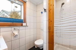 a bathroom with a toilet and a tub and a window at Fewo am See in Olsberg +23 photos