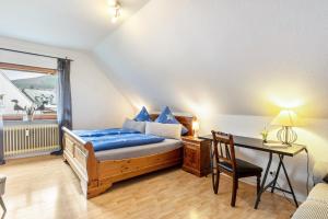 a bedroom with a bed and a desk and a table at Fewo am See in Olsberg