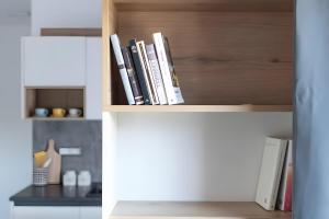 a row of books on a book shelf at Barrosu Studio Apartment in Orosei