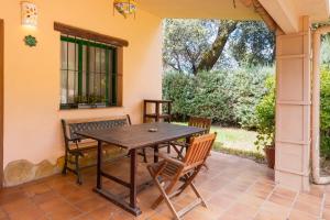 a wooden table and chairs on a patio at Finca Encina - piscina compartida in Alájar