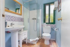 a bathroom with a toilet and a sink and a shower at Finca Encina - piscina compartida in Alájar +13 photos