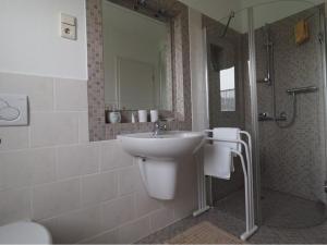 a white bathroom with a sink and a shower at Ferienwohnung Koppelblick in Plattenburg +13 photos