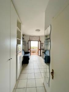 a room with a hallway with a couch and a table at Monolocale Sergi- Piscina In Comune in Stintino
