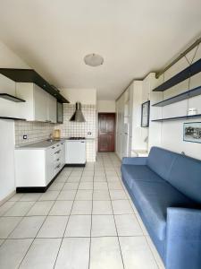 a living room with a blue couch in a kitchen at Monolocale Sergi- Piscina In Comune in Stintino