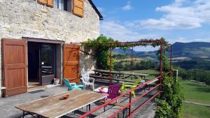 a patio with a wooden table and chairs at Gite De Cabrières in Compeyre