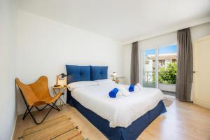 a bedroom with a large bed and a chair at Ca Nostra in Port d'Andratx +24 photos