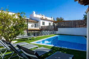 a villa with a swimming pool and lounge chairs at Ca Nostra in Port d'Andratx