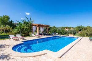 a swimming pool with chairs and a gazebo at Finca Galardo in Son Servera