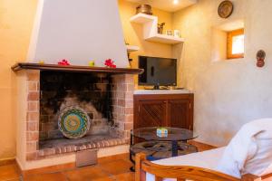 a living room with a fireplace with a table and a tv at Finca Galardo in Son Servera