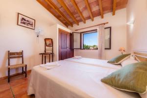 a bedroom with a large white bed and a window at Finca Galardo in Son Servera +23 photos