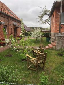 zwei Bänke und ein Tisch in einem Hof in der Unterkunft Lale in Wustrow