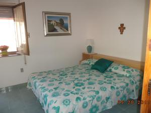 a bedroom with a bed with a green and white comforter at Villetta Mare Ventotene in Ventotene