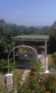a gazebo with a table and chairs in a garden at Villetta Mare Ventotene in Ventotene +12 photos