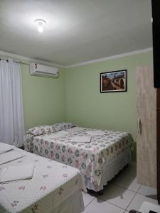 a bedroom with two beds and a picture on the wall at Flats Xingó in Piranhas